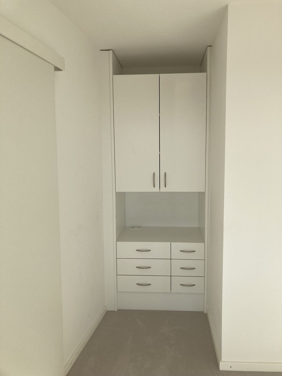 Ein weißer Kleiderschrank mit Schubladen und Schränken
